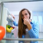 Žena držící se za nos kvůli zápachu v lednici